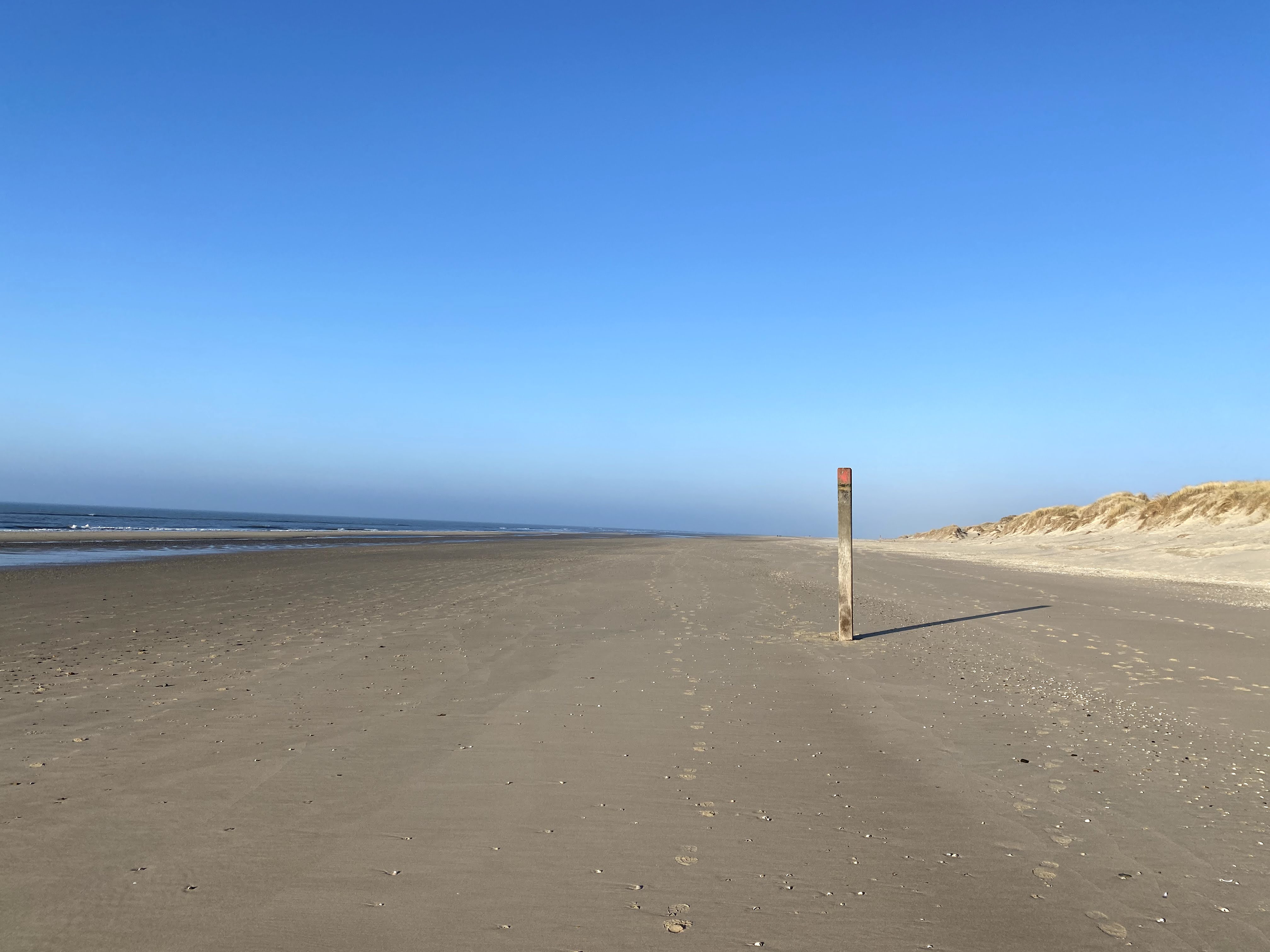 Leeg strand met strandpaal